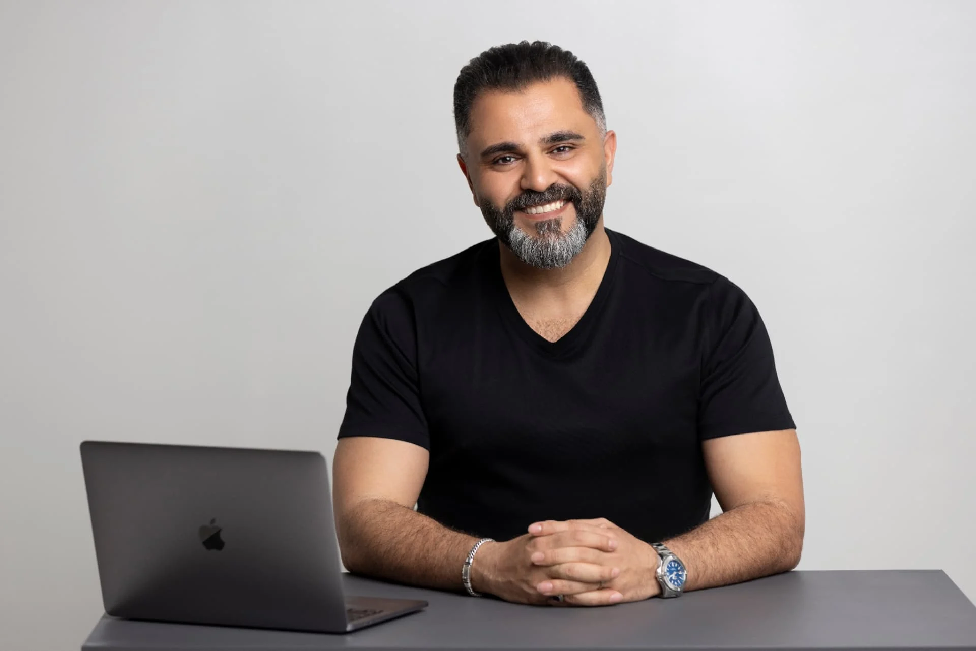 Alaa Hassan, founder of Red Goat Digital, at his desk with a laptop